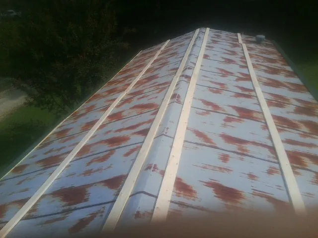 Rusted metal roof panels with new wood purlins before replacement — Storm Damage Roof Repair in Suffolk by Roofing Brothers