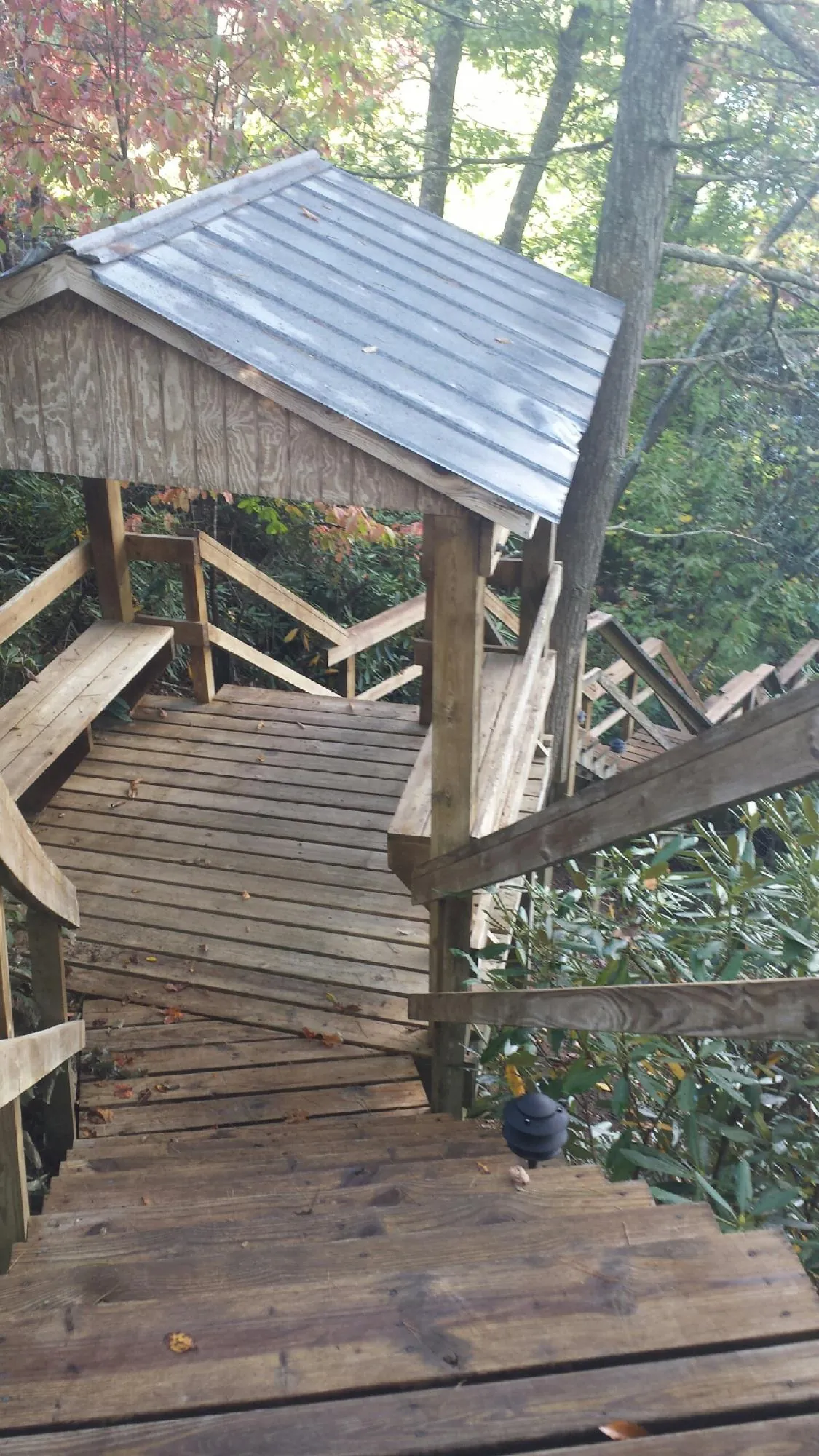 Metal roofed shelter over wooden steps on a wooded walkway — Skylight Repair & Installation work by our crew in Suffolk